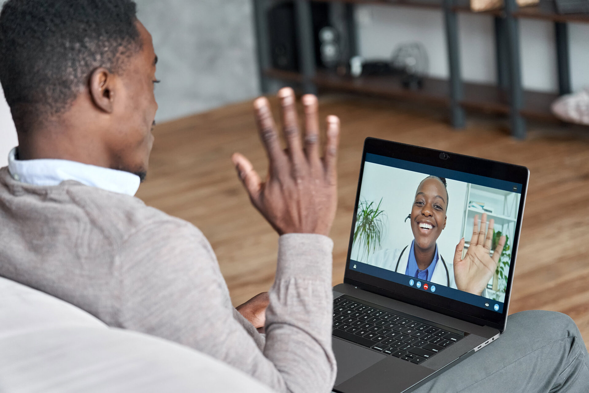 Guy waving at doctor on a computer